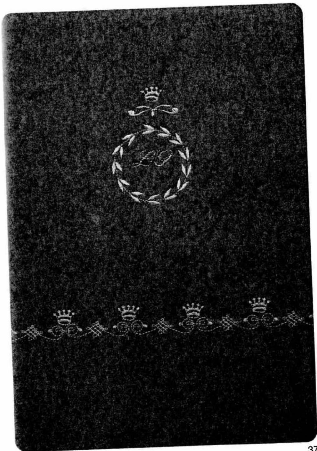 Black-and-white image of a decorative book cover with ornate laurel wreath and crown motifs (no readable text or symbols)