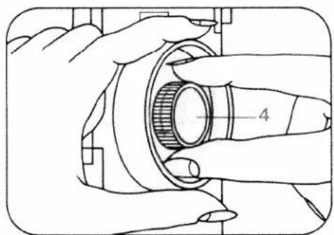 Technical line drawing of a hand turning a mechanical component with a gear-like shaft (no text or symbols)