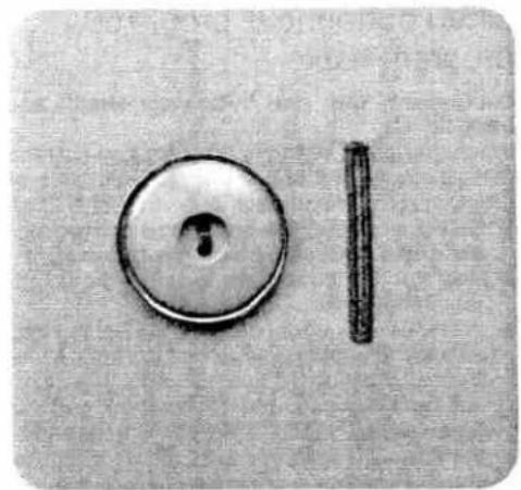 Close-up of a circular mechanical part with a hole and a vertical rod, no visible text or symbols.