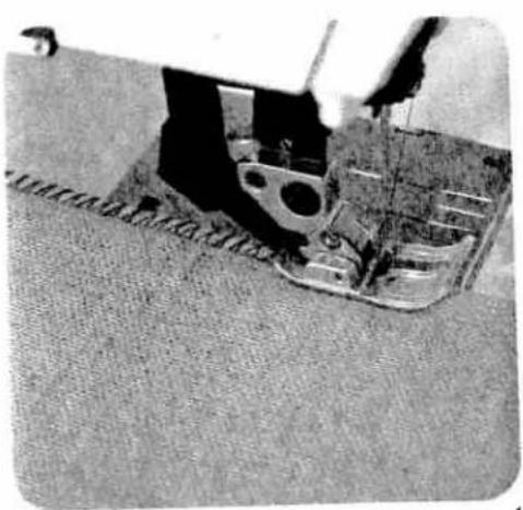 Close-up of a sewing machine stitching fabric (no visible text or symbols)