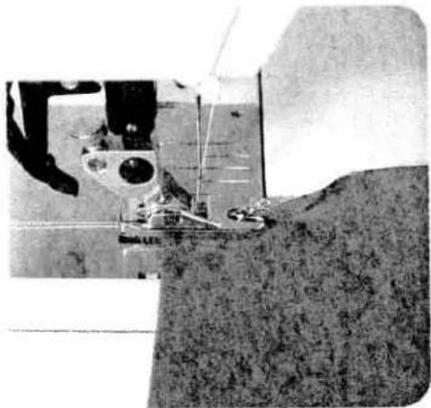 Close-up of a sewing machine needle stitching fabric, no visible text or symbols