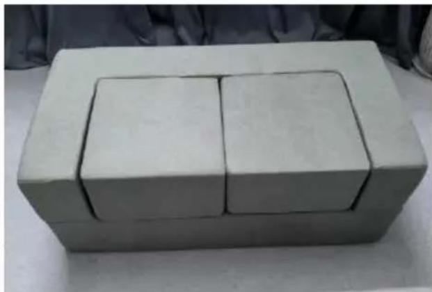 Three white rectangular blocks with black outlines arranged in a rectangular box, placed on a light surface (no text or symbols visible)