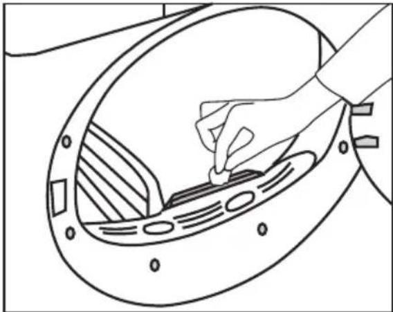 Line drawing of a hand inserting a small component into a circular device (no text or symbols)