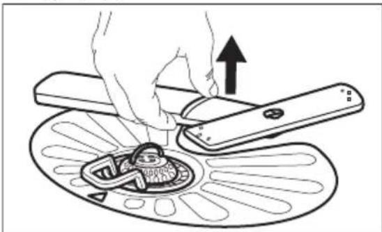 Illustration of a hand using a tool to press a device into a circular component, with an upward arrow indicating motion (no text or symbols present)