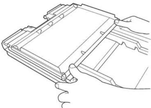 Technical line drawing of a mechanical component with hands operating it (no text or symbols)