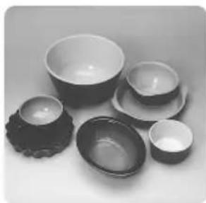 Black-and-white photo of various ceramic bowls and spoons arranged on a plain surface (no text or symbols visible)