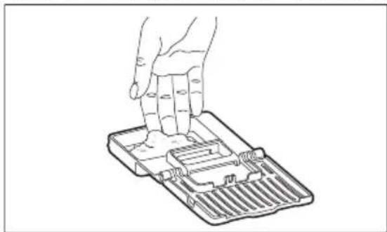 Line drawing of a hand pressing down on a mechanical component (no text or symbols)