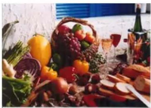 Assorted fresh vegetables and snacks including fruits, vegetables, bread, wine, and bread slices (no visible text or labels)