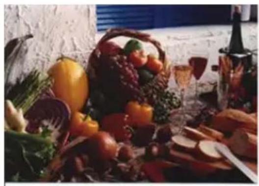 Still life arrangement of assorted vegetables and fruits including a basket, wine bottle, and sliced meat (no text or symbols visible)