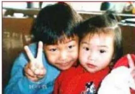 Two children making peace signs together (no visible text or symbols)