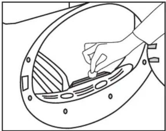 Line drawing of a hand inserting a small component into a circular device (no text or symbols)