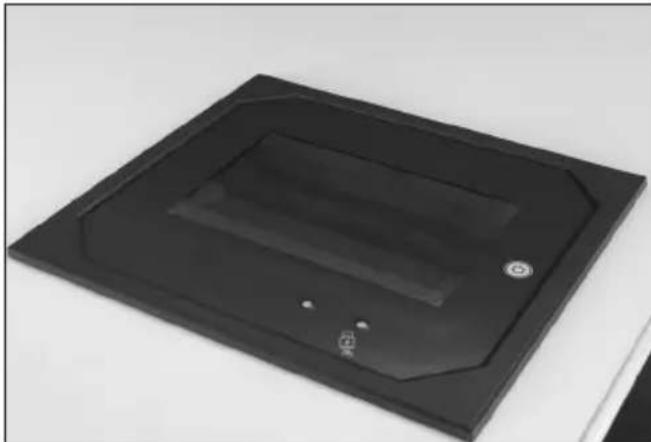 Black rectangular electronic device with a recessed top and mounting holes, placed on a plain surface (no text or symbols visible)
