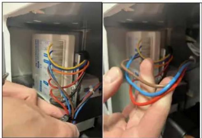 Close-up of hands holding multicolored wires in a technical setup, no visible text or symbols