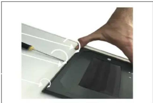 Close-up of a hand pressing down on a laptop screen with a pen, showing no text or symbols