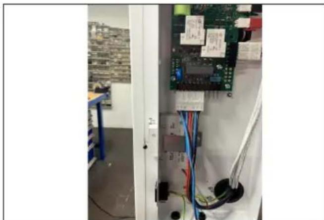 Interior view of an electrical control cabinet with visible wiring and electronic components (no readable text or symbols)