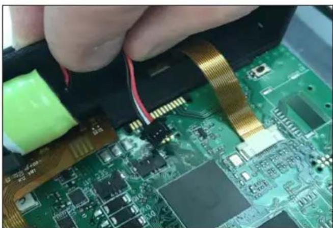 Close-up of hands installing a green printed circuit board with visible traces and components (no text or symbols)