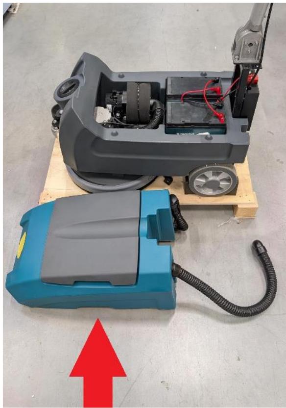 Two industrial cleaning machines on a pallet, one blue and one gray, with a red upward arrow indicating improvement (no text or symbols visible)