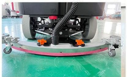 Interior view of a cleaning or cleaning facility with a robotic floor and orange-labeled wheels (no visible text or symbols)