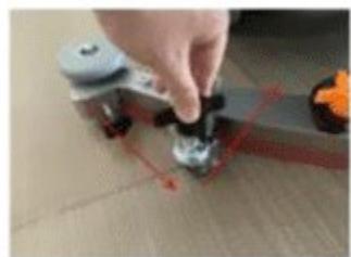 Close-up of a hand adjusting a small mechanical component on a textured surface, with no visible text or symbols.
