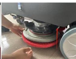 Person cleaning a car tire on a red surface, no visible text or symbols