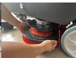 Close-up of a person cleaning a car wheel rim with red filter bands (no visible text or symbols)