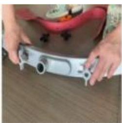 Close-up of hands holding a small electronic device with buttons and a red top (no visible text or symbols)