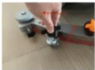 Close-up of a hand adjusting a small mechanical component on a wooden surface (no visible text or symbols)