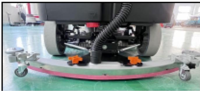 Interior view of a cleanroom facility showing a robotic cleaning machine with orange wheels and wiring (no visible text or symbols)