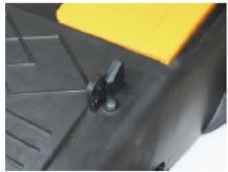 Close-up of a mechanical component with a yellow top and black base, showing a small metallic knob (no text or symbols visible)