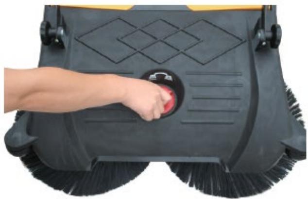 Close-up of a hand pressing a red button on a black square cleaning brush (no text or symbols visible)