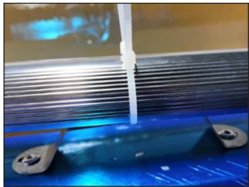Close-up of a blue lab bench with a white plastic tube inserted, no visible text or symbols