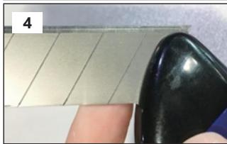 Close-up of a black plastic object being held by fingers against a tiled wall (no text or symbols visible)