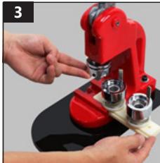 Close-up of hands operating a red microscope with mechanical parts (no visible text or symbols)