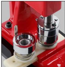 Close-up of a red mechanical component with metallic and brass components (no visible text or symbols)