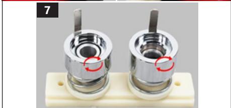 Close-up of two metallic cylindrical mechanical components mounted on a white base plate (no visible text or symbols)