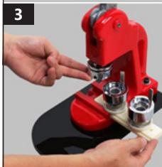 Close-up of hands operating a red microscope with metal components (no visible text or symbols)