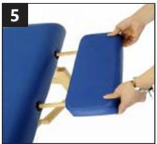 Close-up of a hand holding a blue ergonomic chair with wooden legs (no text or symbols visible)