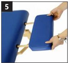 Close-up of a hand holding a blue ergonomic chair seat with wooden legs (no text or symbols visible)