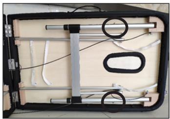 Interior view of a black plastic enclosure with white cables and a circular annotation on the side (no text or symbols visible)