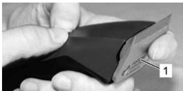 Close-up of hands holding a flexible electronic device with a labeled component (no visible text or symbols)