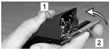 Close-up of hands holding a damaged electronic device with labeled parts (no readable text or symbols)